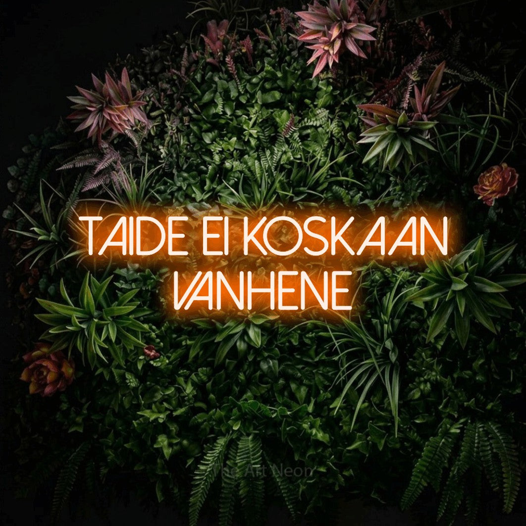LED neon sign reading “taide ei koskaan vanhene”, arranged in 2 lines.