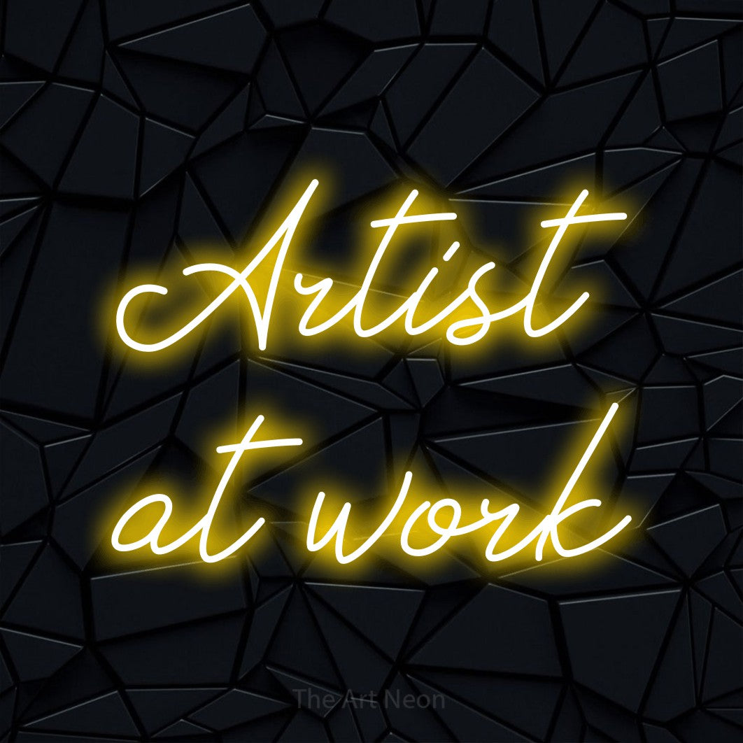 LED neon sign reading “Artist at work”, arranged in 2 lines.