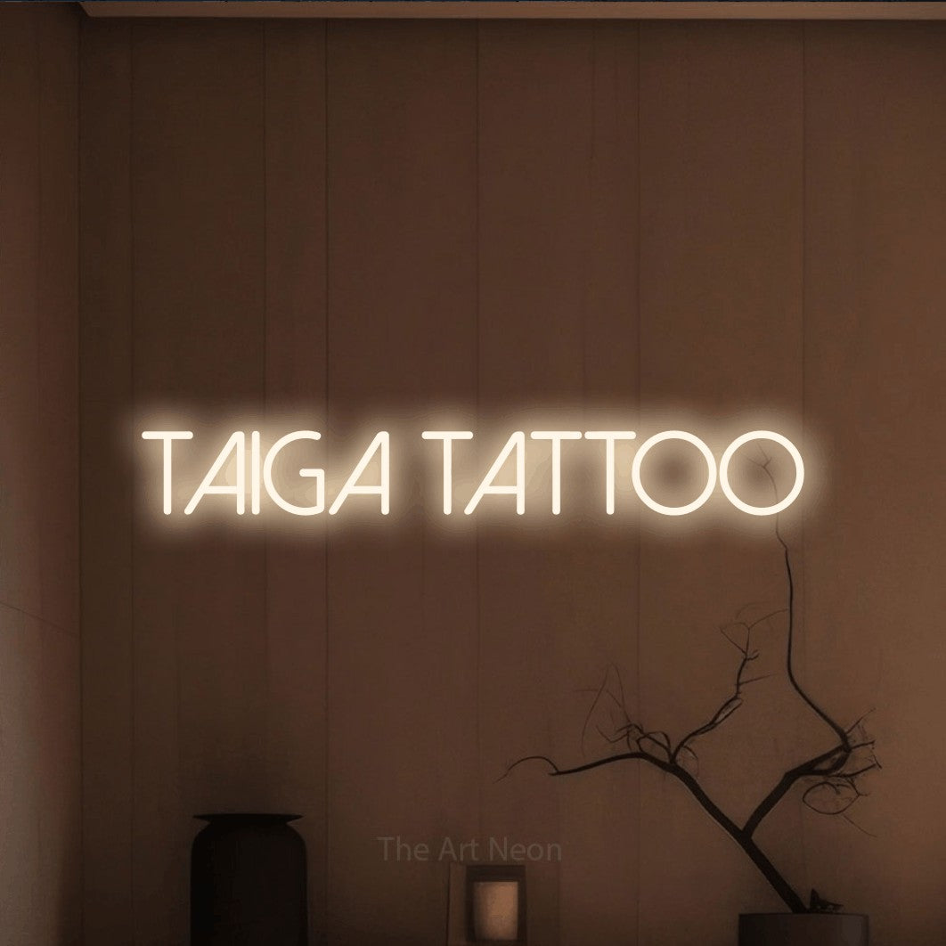 LED neon sign reading “Taiga tattoo”, arranged in a single line.
