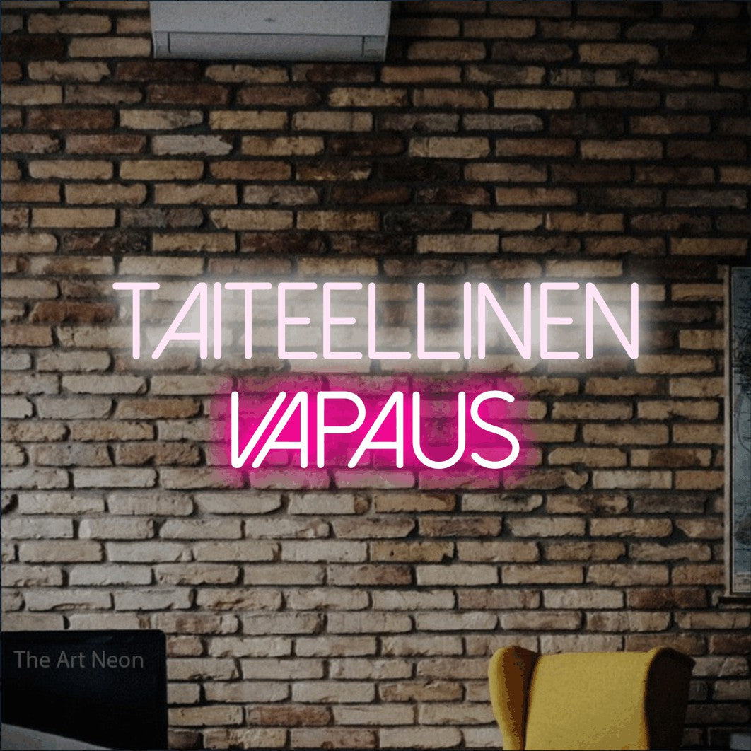 LED neon sign reading “taiteellinen vapaus”, arranged in 2 lines.