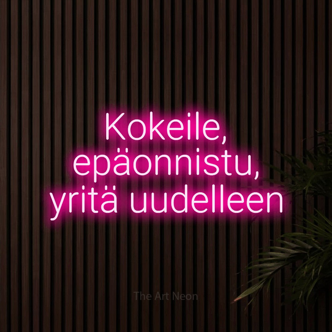 LED neon sign reading “Kokeile, epäonnistu, yritä uudelleen”, arranged in 3 lines.