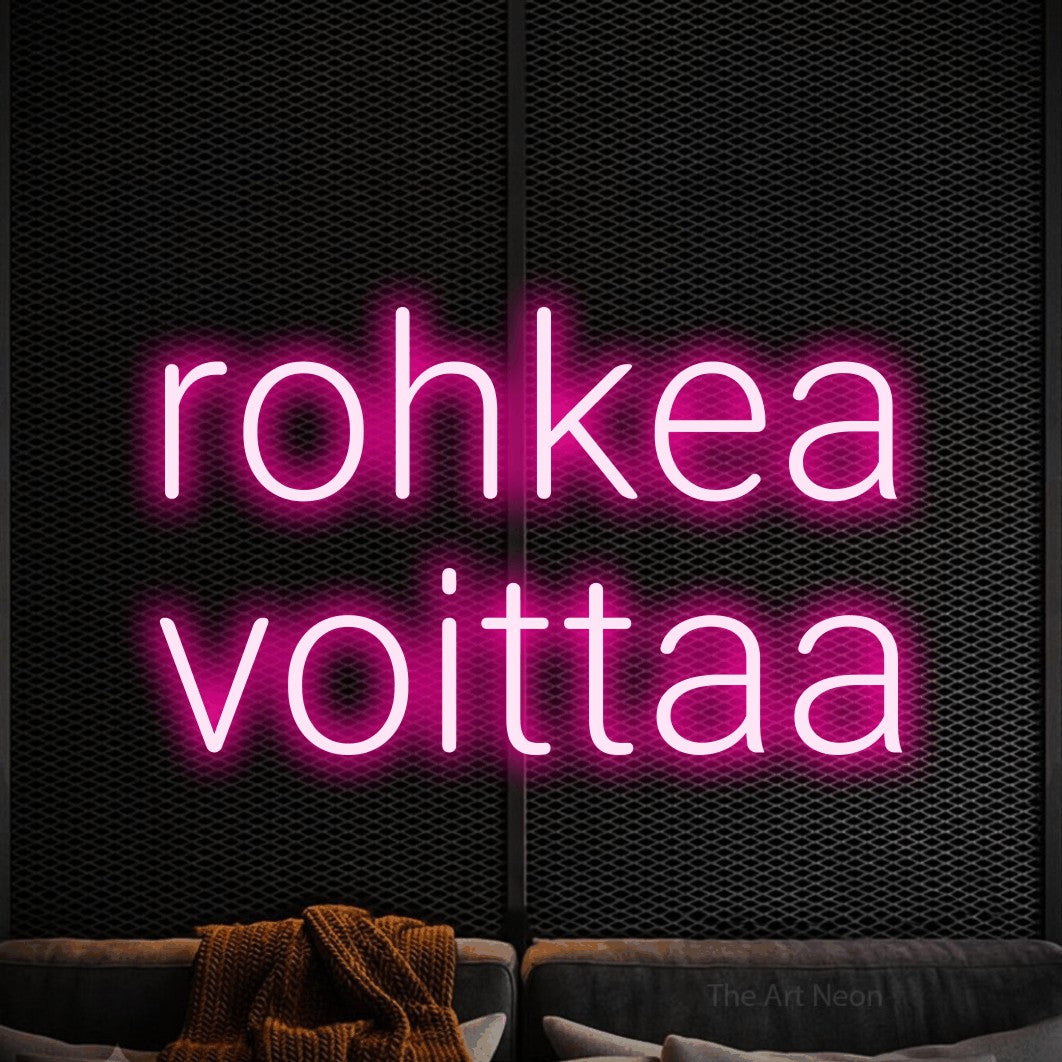 LED neon sign reading “rohkea voittaa”, arranged in 2 lines.