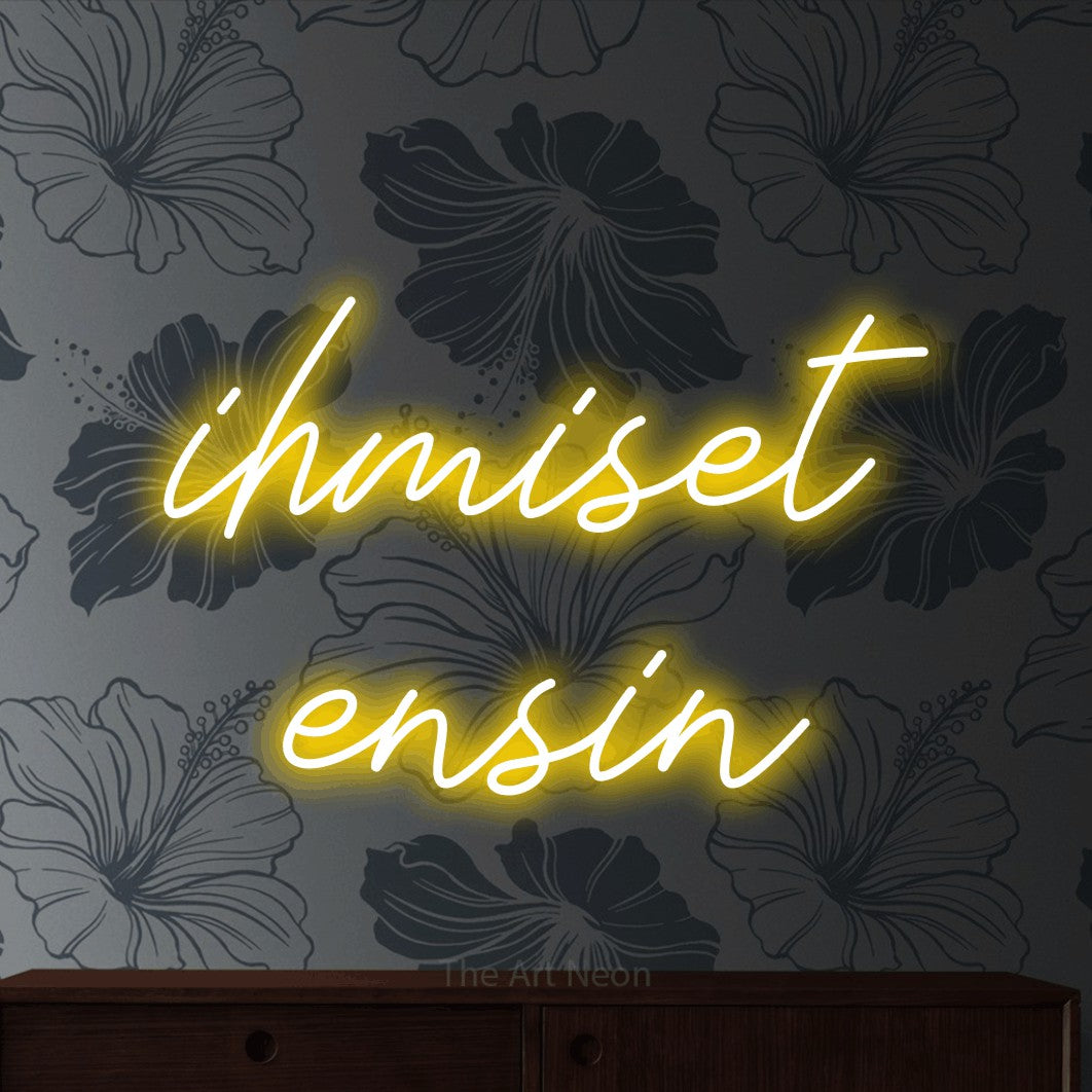 LED neon sign reading “ihmiset ensin”, arranged in 2 lines.