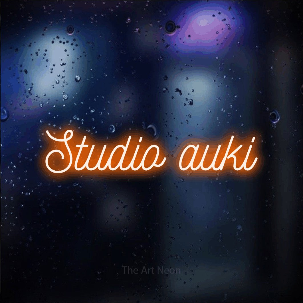 LED neon sign reading “Studio auki”, arranged in a single line.