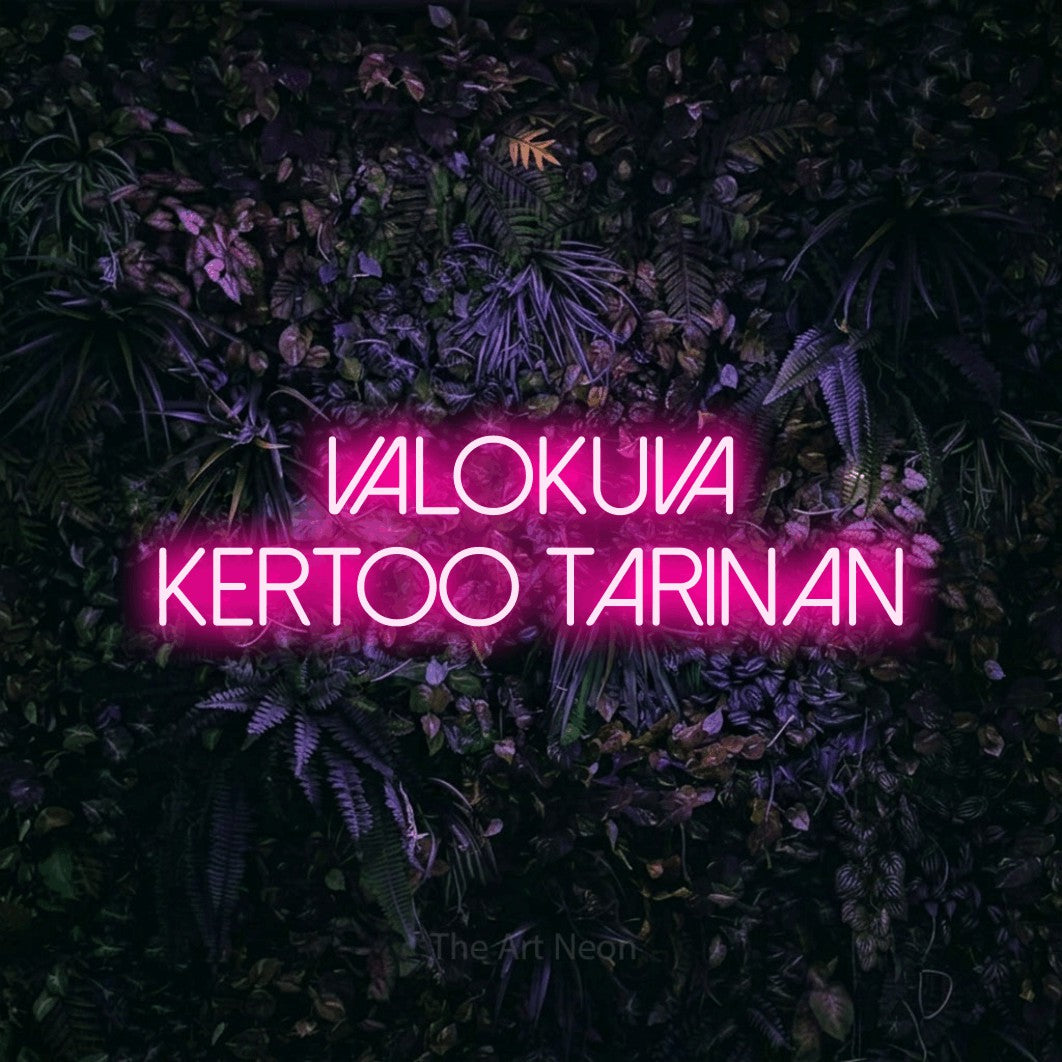 LED neon sign reading “Valokuva kertoo tarinan”, arranged in 2 lines.