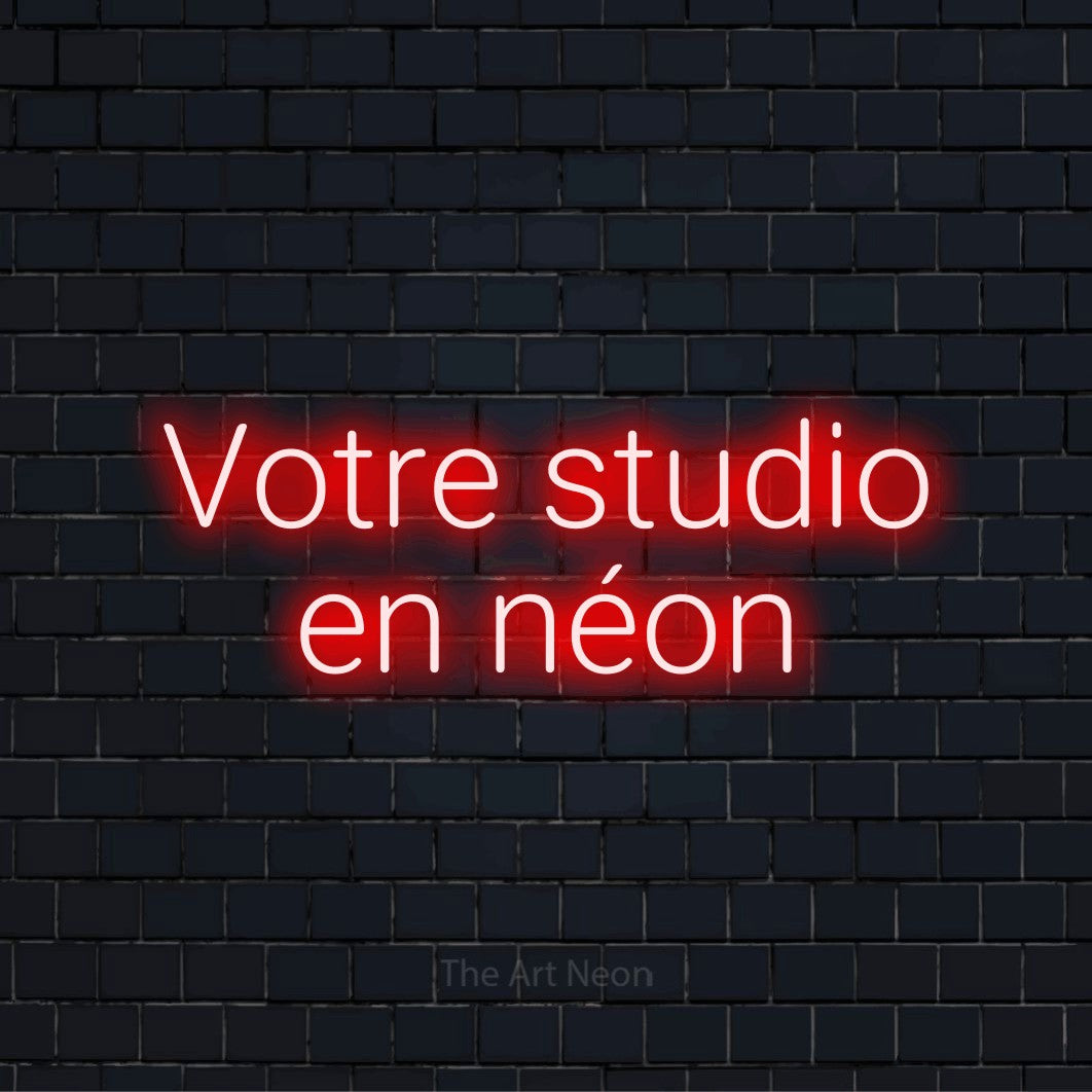 Enseigne néon personnalisée « Votre studio en néon » sur un mur en briques noires