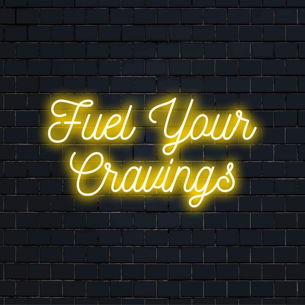 Custom LED neon sign with the phrase Fuel Your Cravings, featuring modern typographic design and vibrant neon colors.