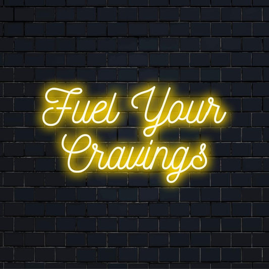 Mukautettu LED-neonkyltti ilmauksella Fuel Your Cravings, jossa on moderni typografinen muotoilu ja kirkkaat neonvärit.