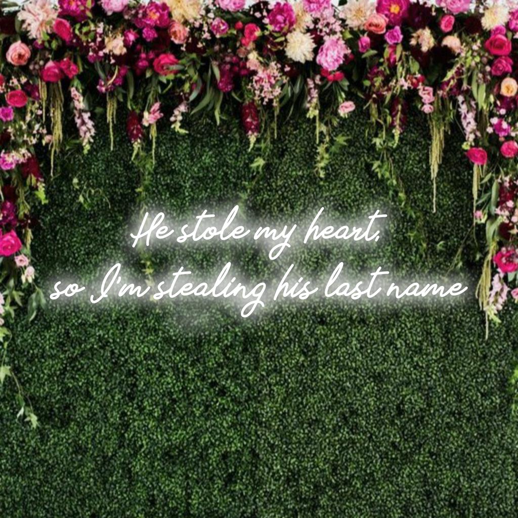 Mukautettu LED-valokyltti, jossa lukee "Hän varasti sydämeni", joten varastan hänen sukunimensä hehkuvassa neonvalossa.