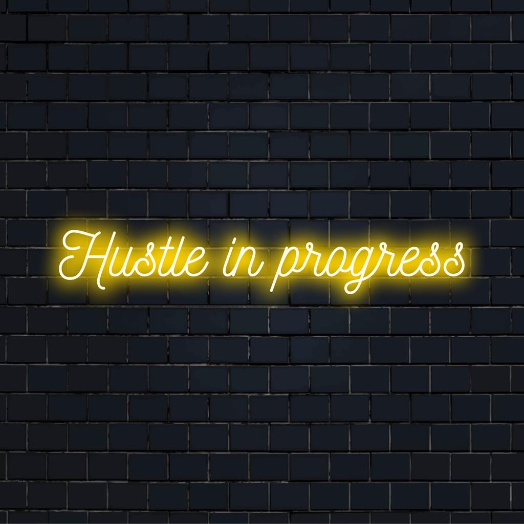 Mittatilaustyönä valmistettu LED-valokyltti, jossa lukee Hustle In Progress, on ihanteellinen motivoivaan sisustukseen koti- tai toimistotiloissa.