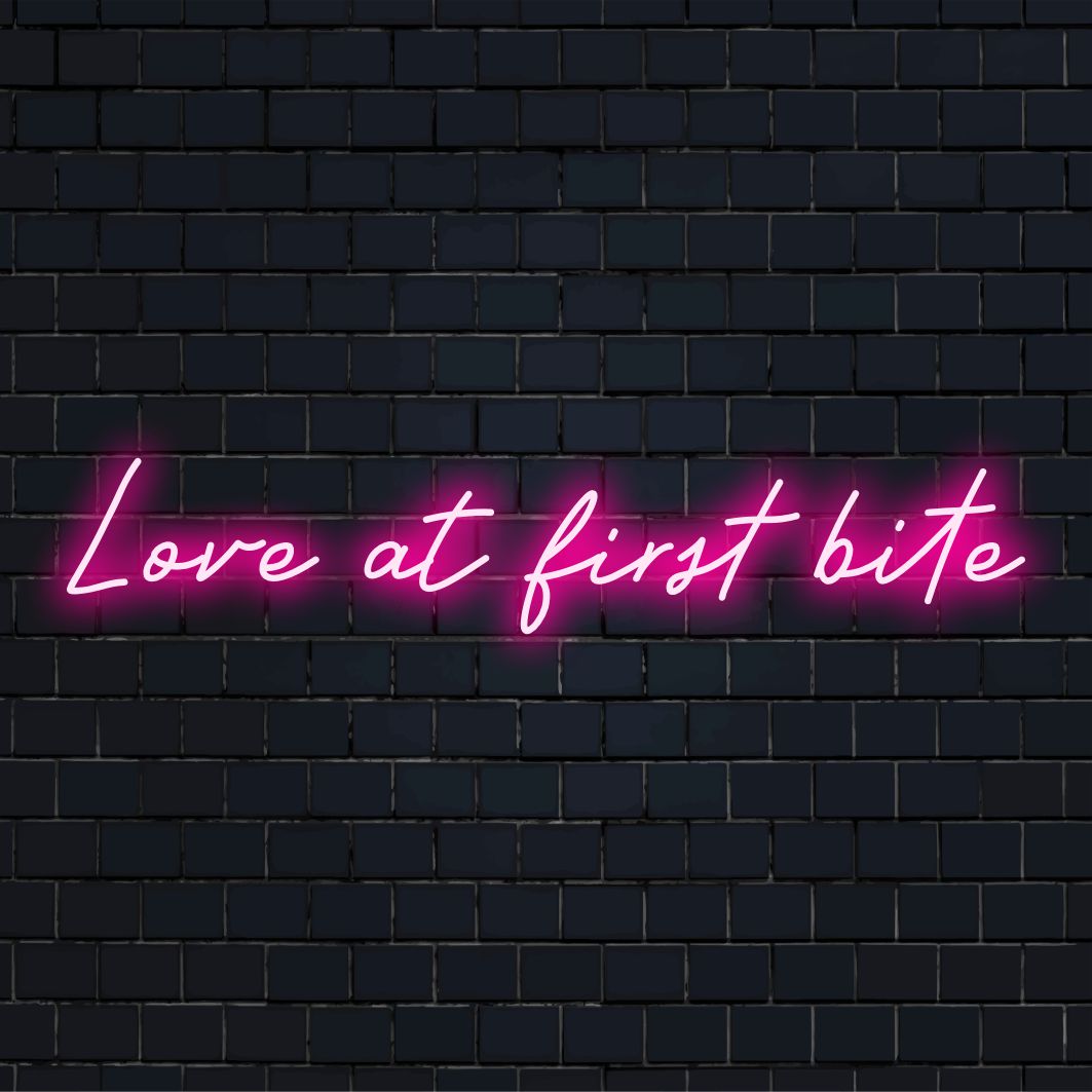 LED-valokyltti Love At First Bite -tekstillä; täydellinen lisäämään leikkisää, persoonallista ilmettä mihin tahansa tilaan.
