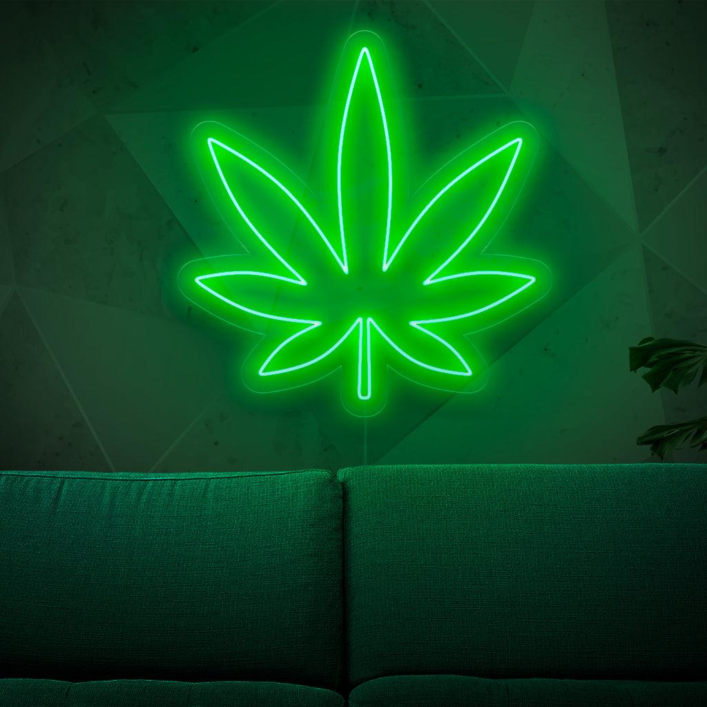 Valaistu neonkyltti, jossa on marihuananlehti, joka symboloi kannabista ja rikkakasvikulttuuria ja lisää ripauksen yrttistä charmia mihin tahansa tilaan
