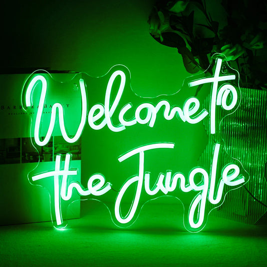 The image features a vibrant LED neon sign displaying the words "Welcome to the Jungle" in bold, cursive script.