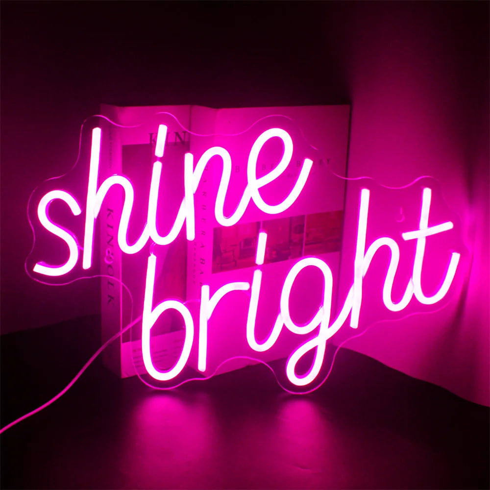 Kuvassa on eloisa ja tyylikäs LED-valokyltti, jossa lukee "Shine Bright" elegantilla, kursiivisella käsialalla.