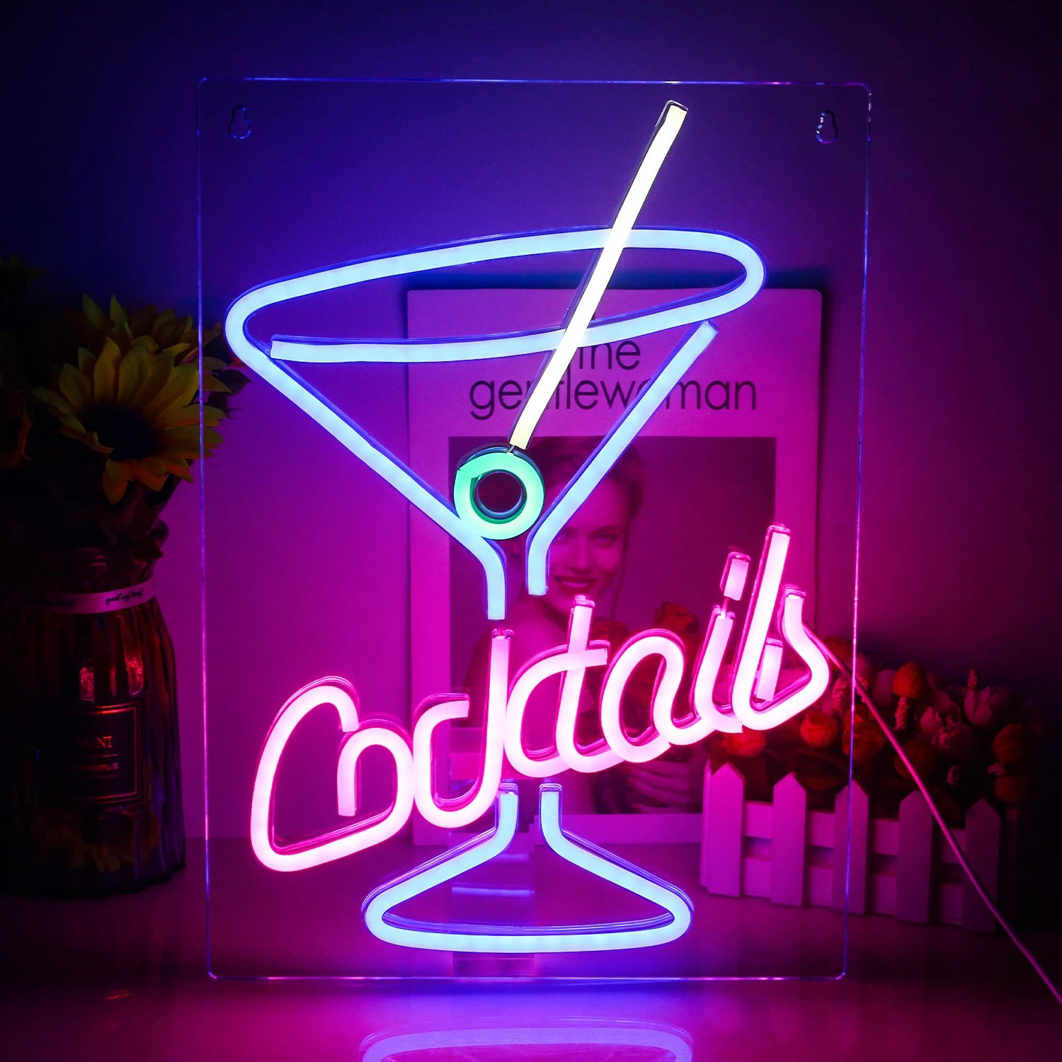 The image depicts a vibrant LED neon sign displaying the word "Cocktails" in an elegant and stylish cursive font.