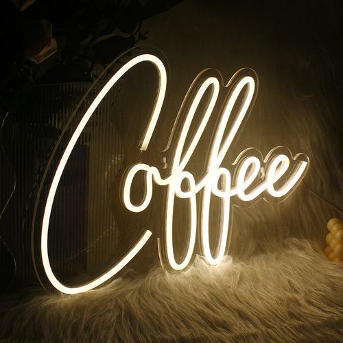 En levande LED-neonskylt formad som en rykande kaffekopp som lyser upp ett varmt bärnstensfärgat sken.
