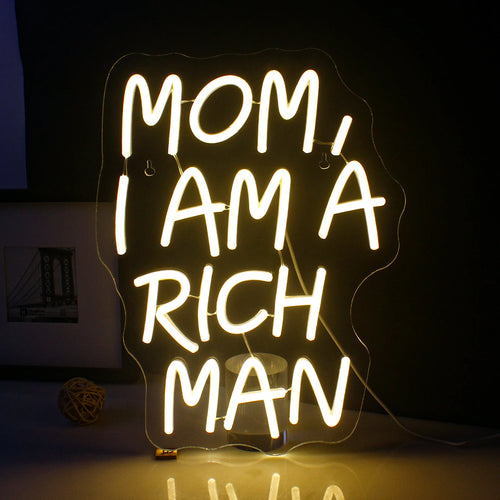Eloisa LED-valokyltti, jossa on teksti "Mom I Am A Rich Man" eleganteilla ja kursiivisilla kirjaimilla.