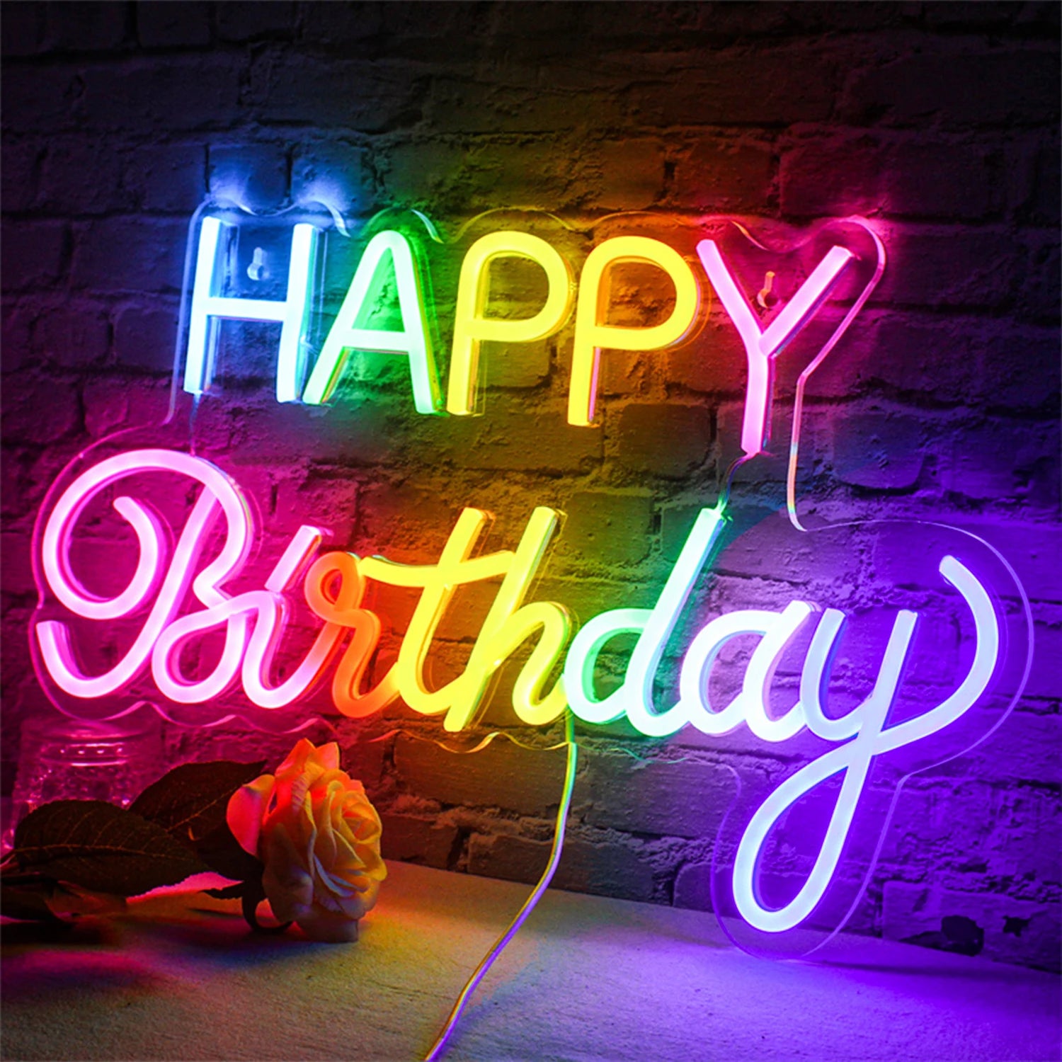 A vibrant LED neon sign displays the words "Happy Birthday" in a playful, cursive font formed by luminous tubing.