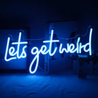 Kuvassa näkyy elävä "Let's Get Weird" -LED-valokuva seinälle asennettuna.