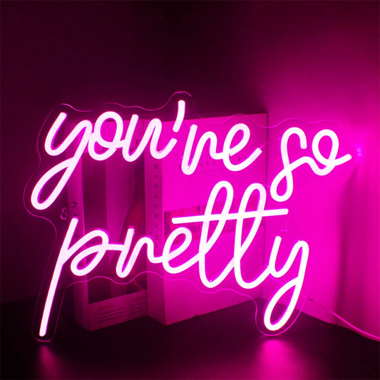 A vibrant LED neon sign displaying the words "You’re so pretty" in elegant cursive script.