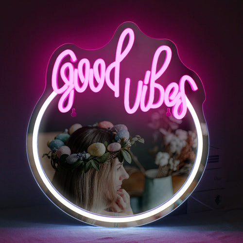 Kuvassa on tyylikäs LED-valokyltti, jossa lukee "Good Vibes" kirkkain, hehkuvan vaaleanpunaisin kirjaimin.