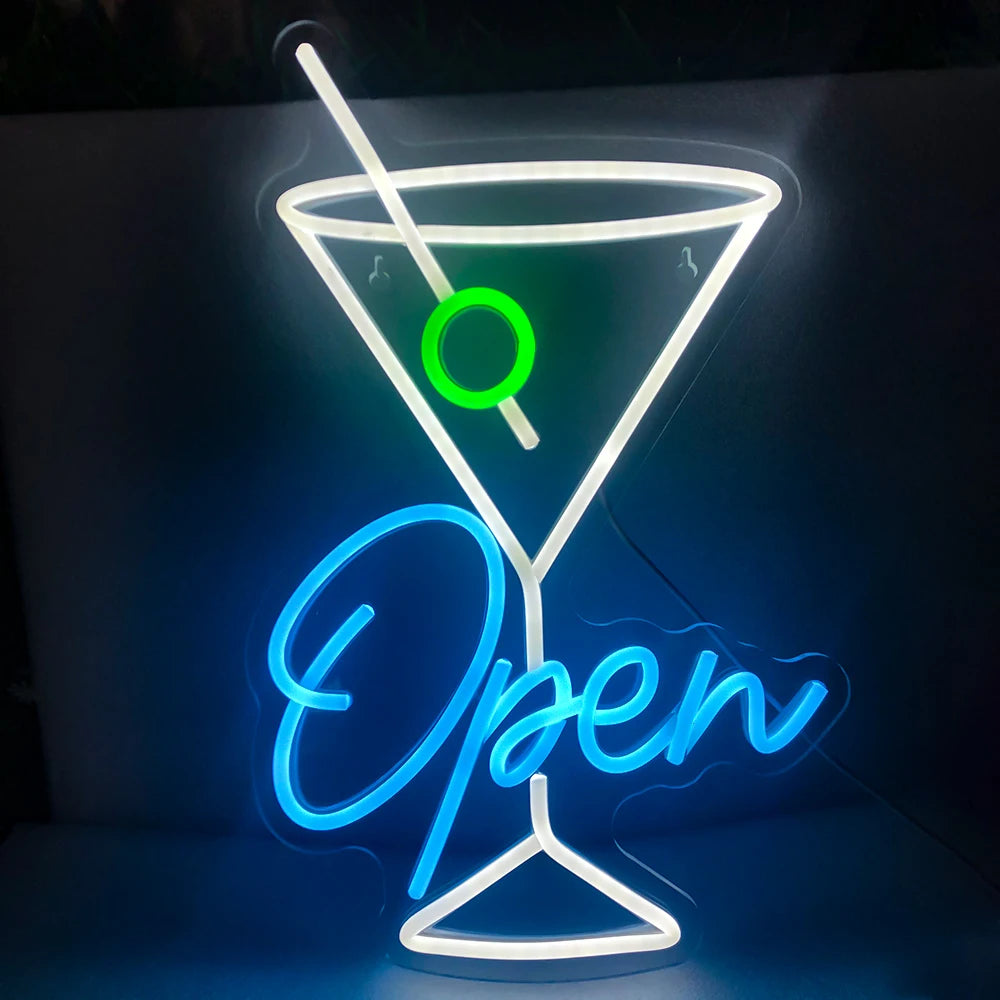 The image features a vibrant LED neon sign designed in the shape of an open wine glass.