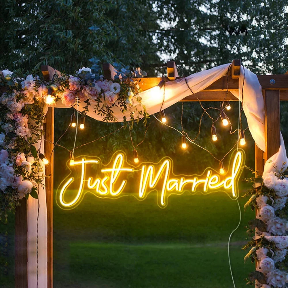 Hehkuva LED-valokyltti, jossa on sana "Just Married" tyylikkäällä kursiivisella tekstillä.