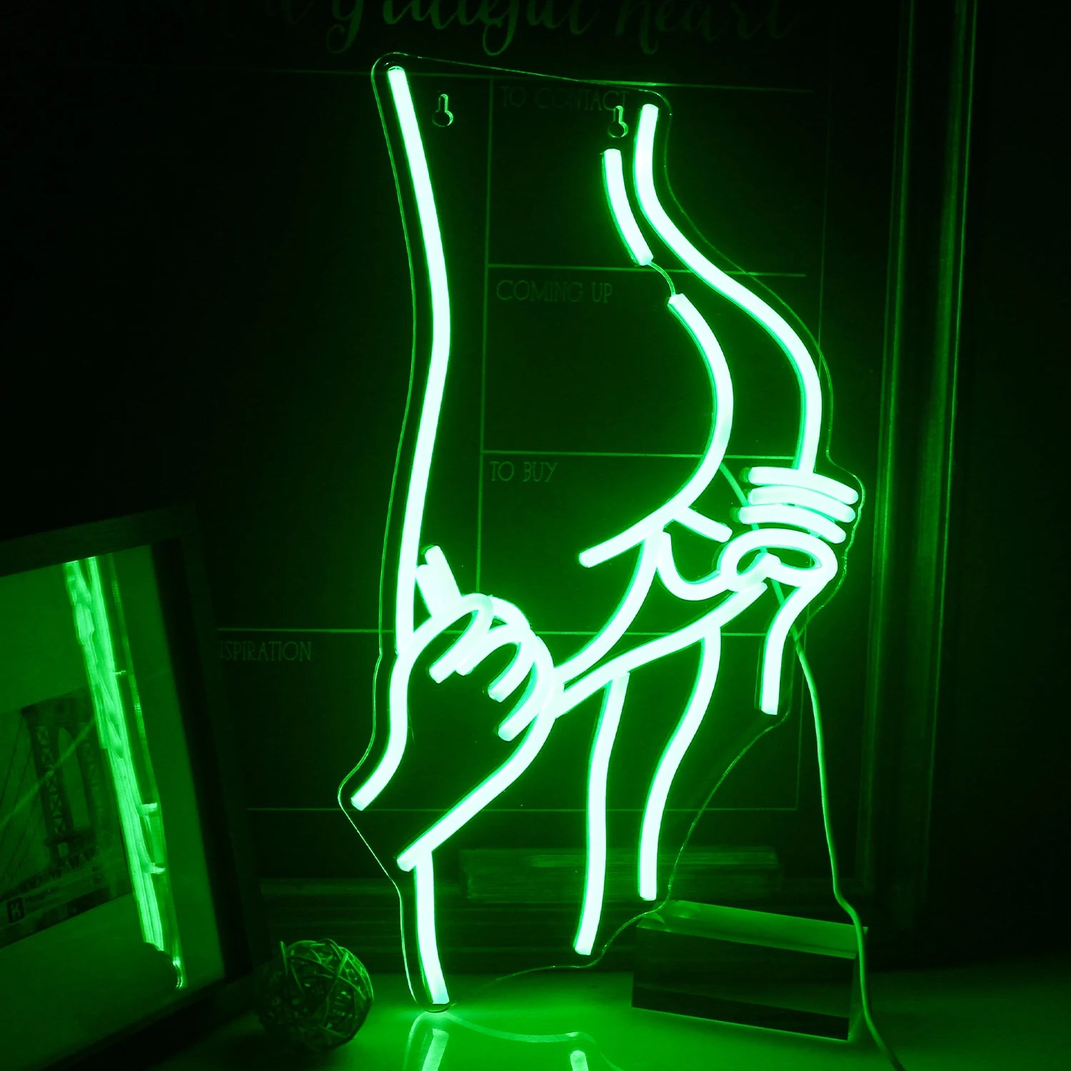 The image features a vibrant LED neon sign in the shape of a silhouette depicting a sensual, curvaceous figure of a woman.