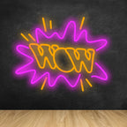 A vibrant LED neon sign with the word "WOW" illuminated in glowing pink letters against a dark background.
