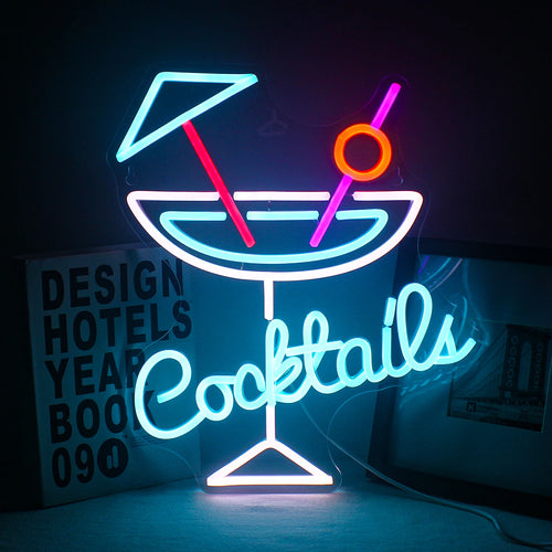 Kuvassa on eloisa LED-neonkyltti, jossa näkyy sana "cocktails" leikkisällä, kursiivisella fontilla.