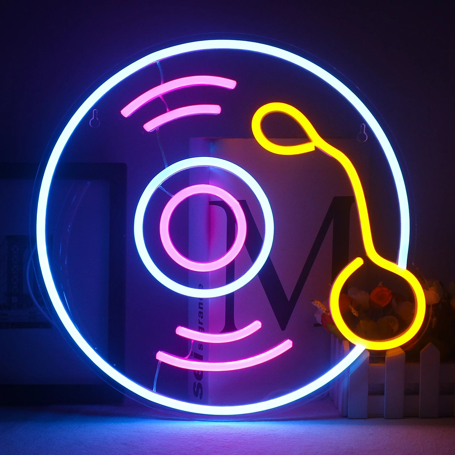 The image shows a vibrant LED neon sign in the shape of a classic vinyl record.