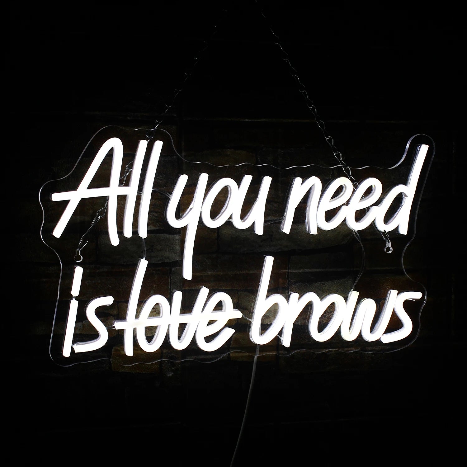 Kuvassa näkyy eloisa "All you need is brows" -LED-valokyltti.