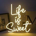 Kuvassa on eloisa, käsintehty LED-neonkyltti kirkkaissa, hehkuvissa väreissä, jotka ilmaisevat lauseen "Life is Sweet.