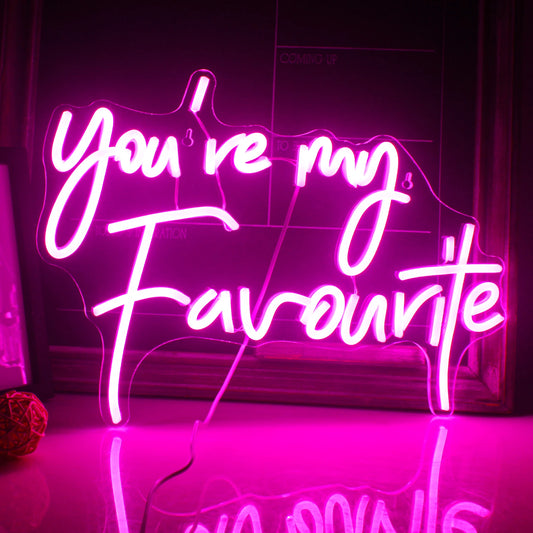 The image features a vibrant, handmade LED neon sign that spells out "You're my favorite" in a playful, cursive font.