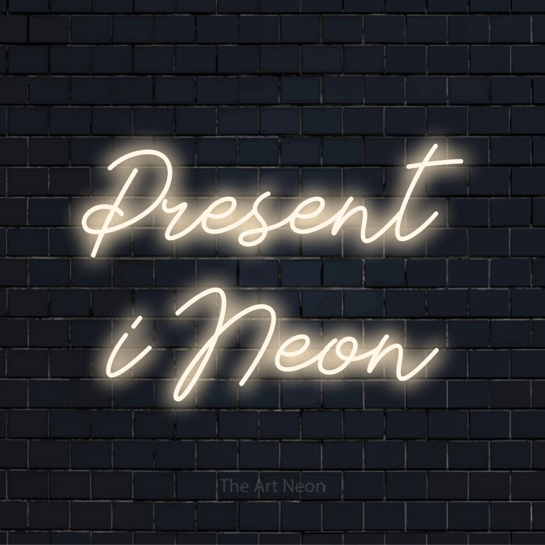 Personlig neonskylt med texten “Present i Neon” på en svart tegelvägg