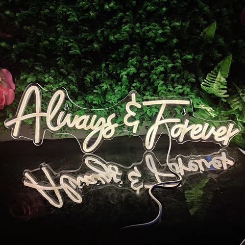 Bilden har en glödande LED-neonskylt som visar orden "Always Forever" i elegant, kursivt manus.