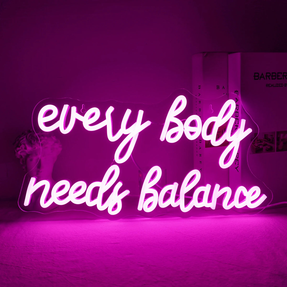 Kuvassa näkyy eloisa "Every Body Needs Balance" -LED-valokyltti.