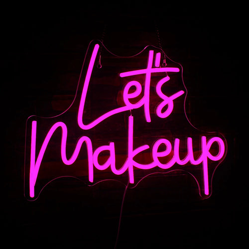 Tyylikäs LED-neonkyltti, jossa on teksti "Let's Makeup" kirkkain vaaleanpunaisin kursiivisin kirjaimin.