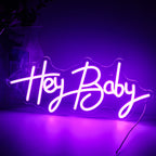 Kuvassa on eloisa, käsintehty LED-valokyltti, jossa lukee "Hey Baby" leikkisällä kursiivikirjasimella.