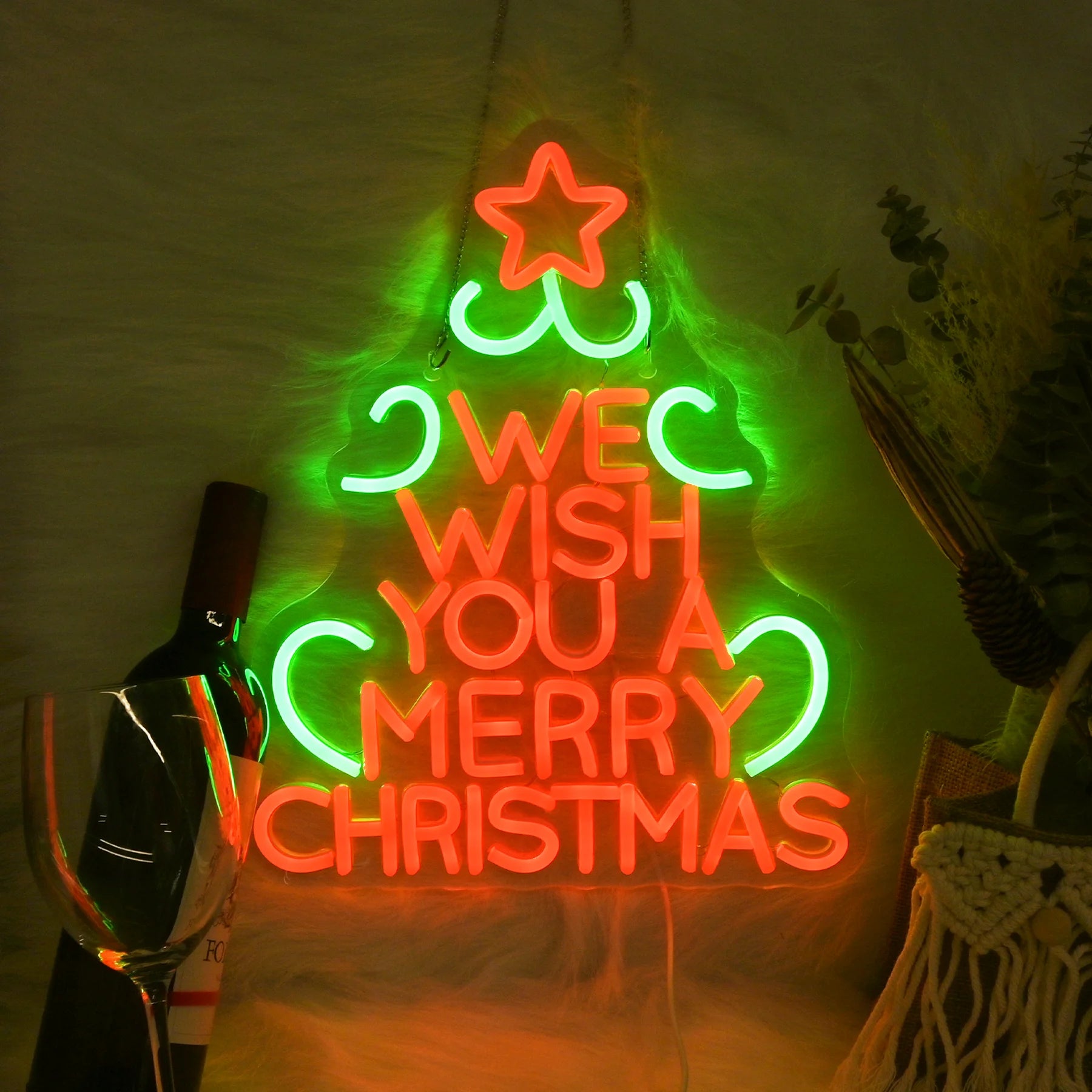 Kuvassa on eloisa LED-valokyltti, jossa lukee "We Wish You A Merry Christmas" juhlallisella, kursiivisella fontilla.