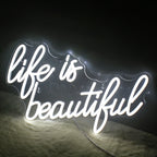 En levande, handgjord LED-neonskylt som visar frasen "Life is Beautiful" i elegant, flytande manus.