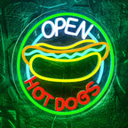 Kuvassa on kirkkaasti valaistu LED-valokyltti, jossa lukee "Open Hot Dogs" leikkisällä, retro-fontilla.