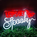 Kuvassa on eloisa LED-valokyltti, jossa on sanat "Let's Get Spooky" lihavoitulla, omituisella fontilla.