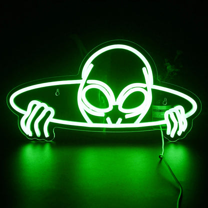 A vibrant LED neon sign shaped like an alien head, featuring large, almond-shaped eyes.