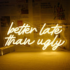 A vibrant LED neon sign displaying the phrase "Better Late Than Ugly" in a stylish handwritten script font.