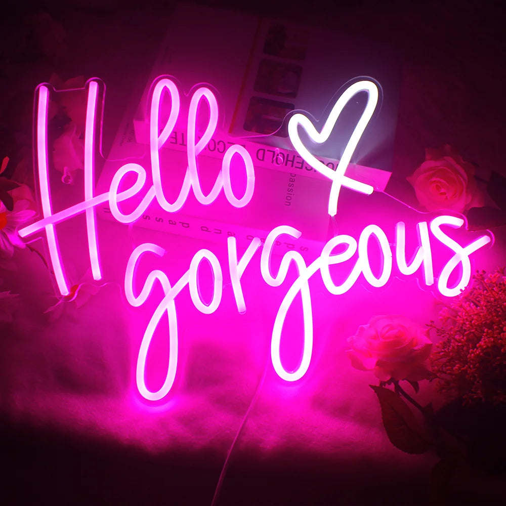 Kuvassa on käsintehty LED-valokyltti, jossa on sanat "Hello Gorgeous" tyylikkäällä kursiivisella tekstillä.