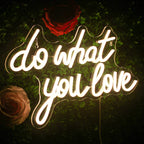 Kuvassa on eloisa LED-valokyltti, jossa on motivoiva lause "Do What You Love" lihavoituin, kursiivisin kirjaimin.