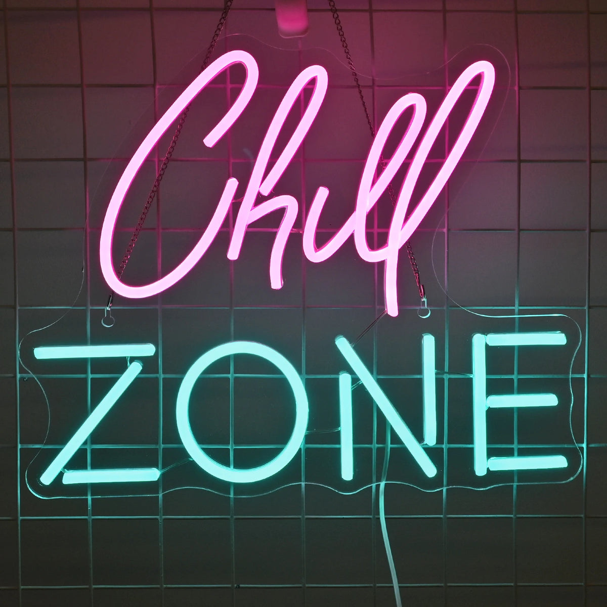 Kuvassa on eloisa LED-valokyltti, jossa on sanat "Chill Zone" tyylikkäällä kursiivilla fontilla.