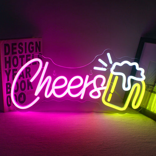 Kuvassa on eloisa "Cheers" LED-neonkyltti, joka on valaistu tummaa taustaa vasten.
