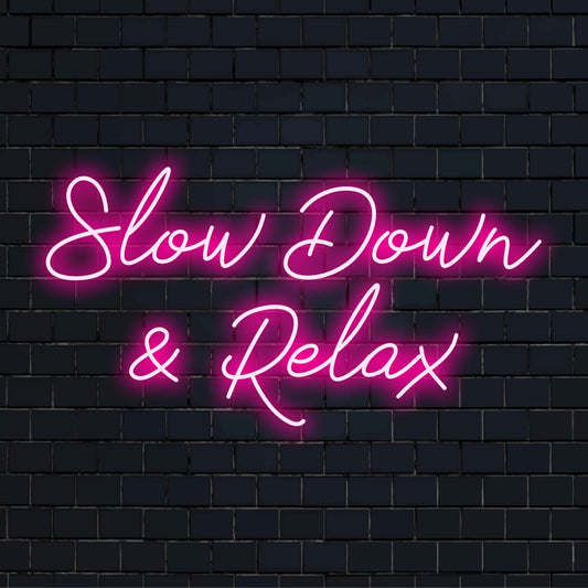 LED-valokyltti, jossa on sanat "Hidasta ja rentoudu"; rauhoittava, mittatilaustyönä valmistettu neon-sisustuskappale rauhalliseen tunnelmaan.